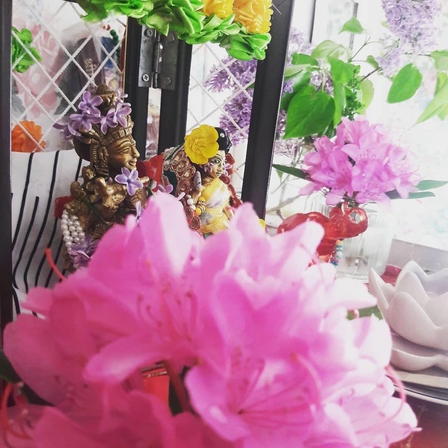 A Krishna devotional altar surrounded by flowers
